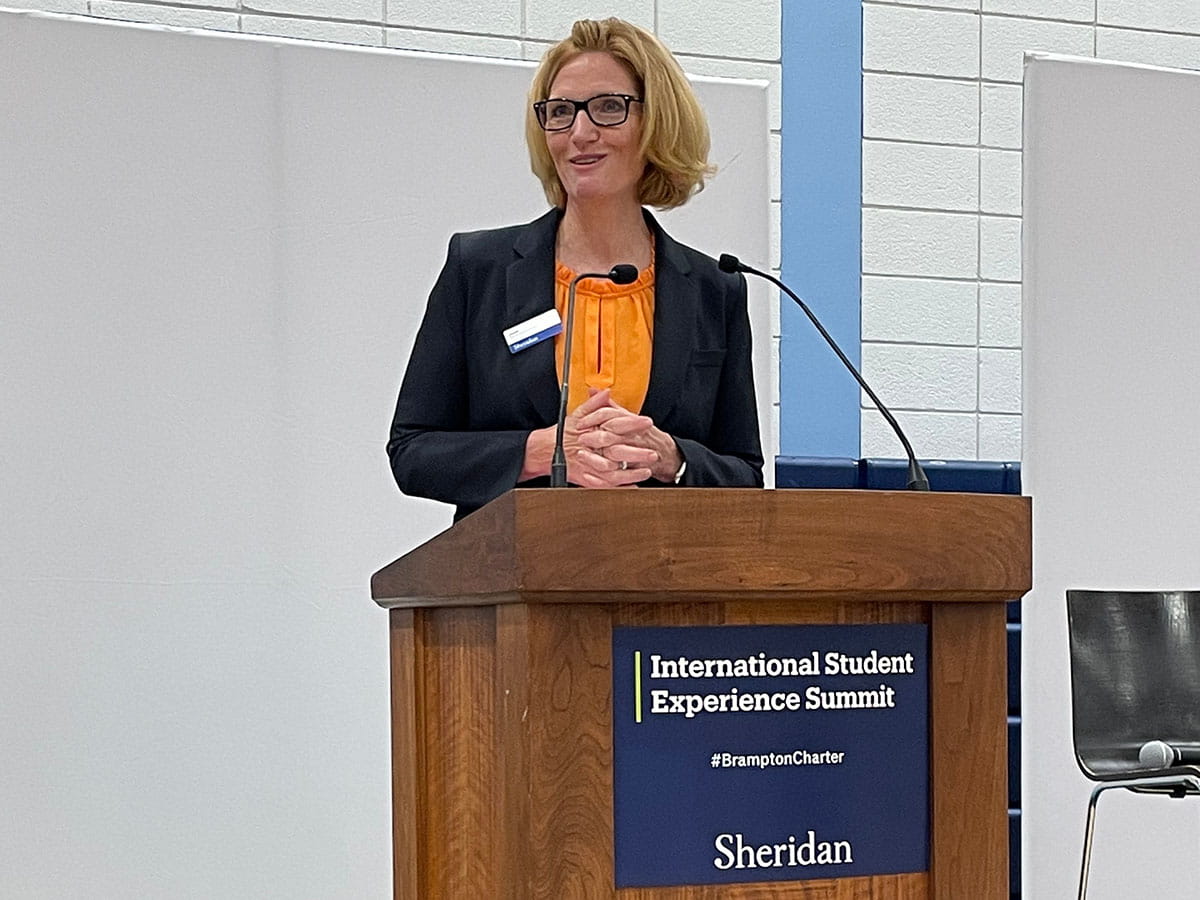 Janet Morrison standing behind a podium that reads 'International Student Experience Summit'