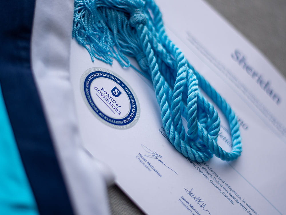 Certificate with sash in Sheridan colours laying on top.