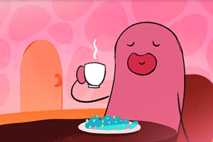 Pink figure sitting at a table and holding a hot beverage