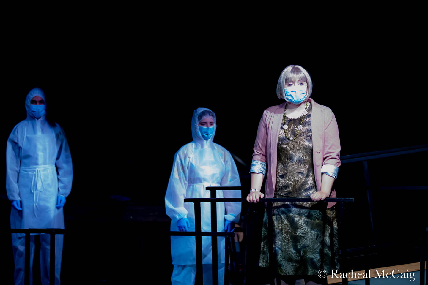 Actors performing dressed in masks and personal protective equipment