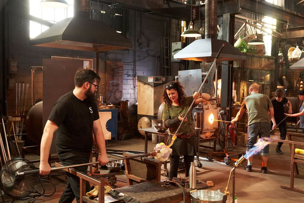 Glassblowers working with glass on the set of Netflix's Blown Away