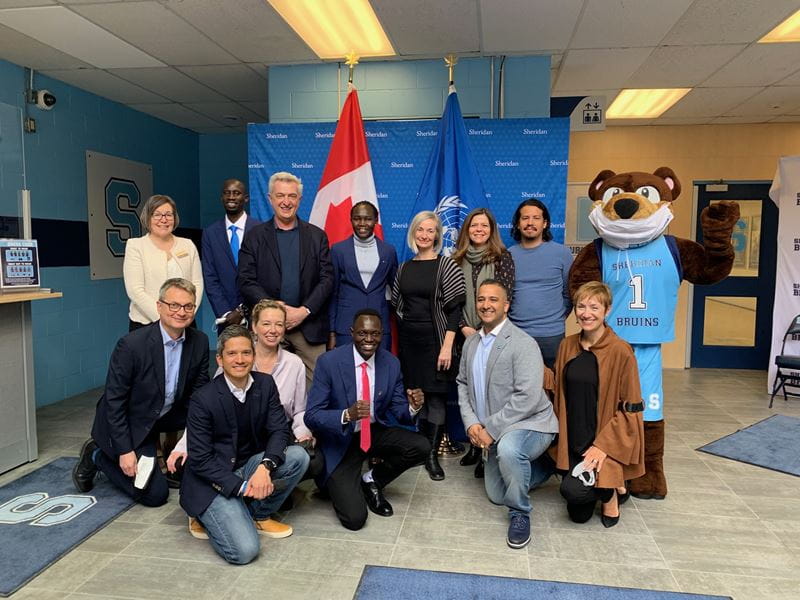 Various Sheridan executives and leaders pose for a photo with refugee athletes Rose Nathike Lokonyen, Paulo Amotun Lokoro and James Nyang Chiengjiek during a visit from the United Nations High Commissioner for Refugees, Filippo Grandi in April 2022