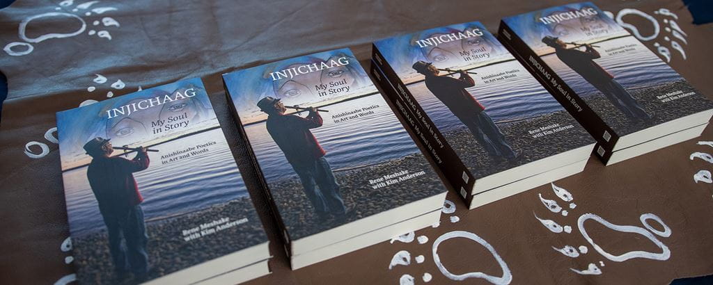 Copies of Rene Meshake's book: Injichaag: My Soul in Story: Anishinaabe Poetics in Art and Word