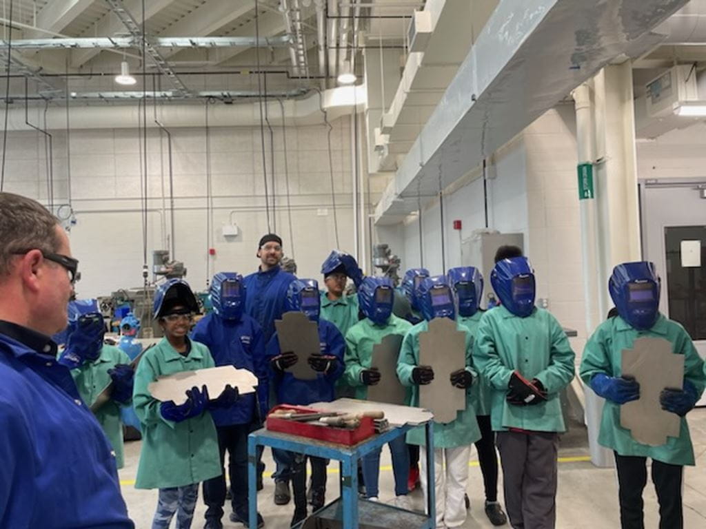 Students from Fletcher's Creek Senior Public School in Brampton wait in line to weld a toolbox in Sheridan's welding lab at Magna Skilled Trades Centre