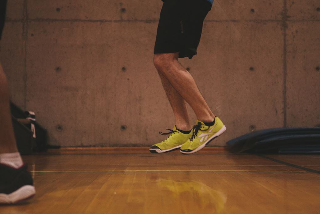 Person with yellow athletic running shoes jumping off the ground