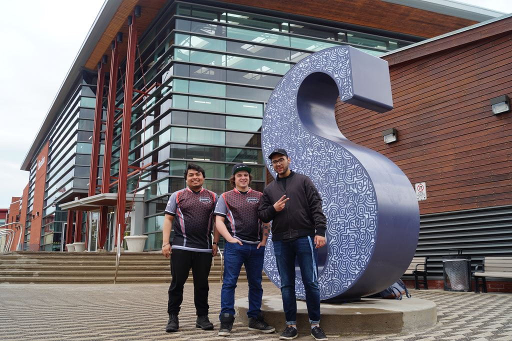 Sheridan eSports team members standing in front of the Sheridan "S" sculpture at Trafalgar Campus