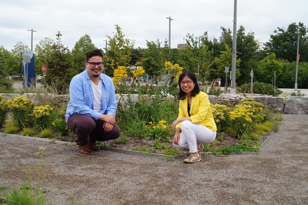 Elijah Williams and Wai Chu Cheng kneeling by the Medicine Wheel Garden