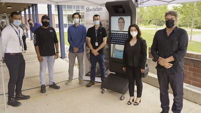 Sheridan staff, faculty and students stand next to the new AVA prototype they helped create.