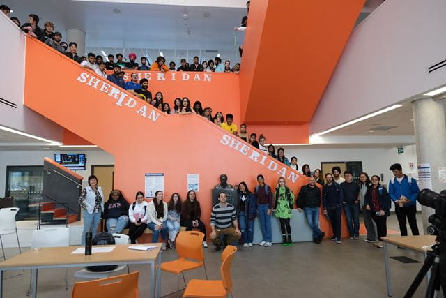 Students and staff from Sheridan's architecture programs line the staircase in the atrium of Sheridan's Hazel McCallion Campus in Mississauga.