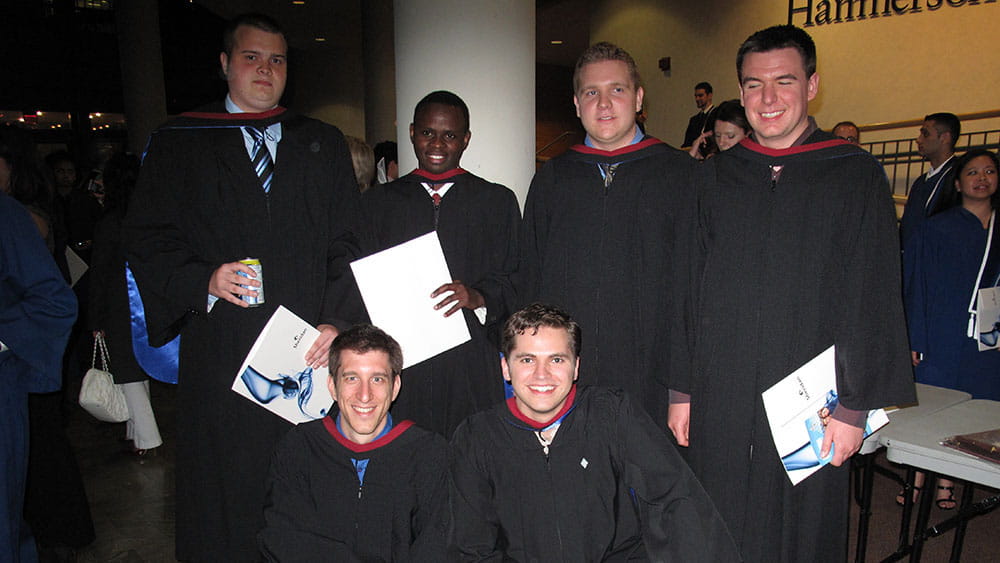 Students in the first cohort of graduates from the Bachelor of Applied Information Sciences - Information Systems Security program pose for a picture in their robes.