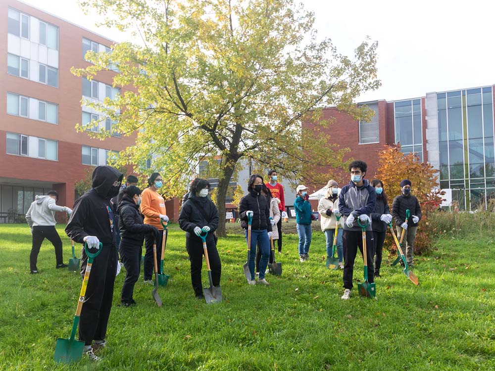 Volunteers from Sheridan's Mission Zero standing with shovels in front of Sheridan's Davis Campus