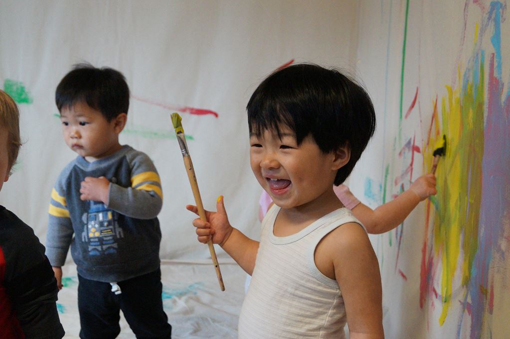 Smiling child holding a paintbrush
