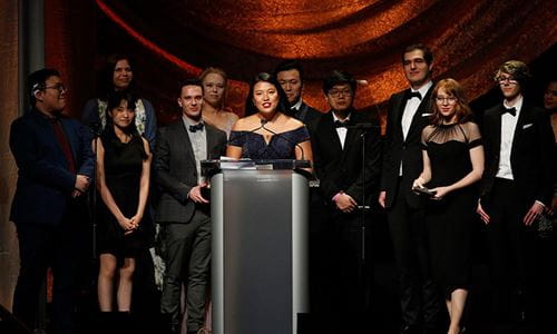 Sheridan Animation student Michelle Chua accepting the Annie Award with her fellow students on stage behind her