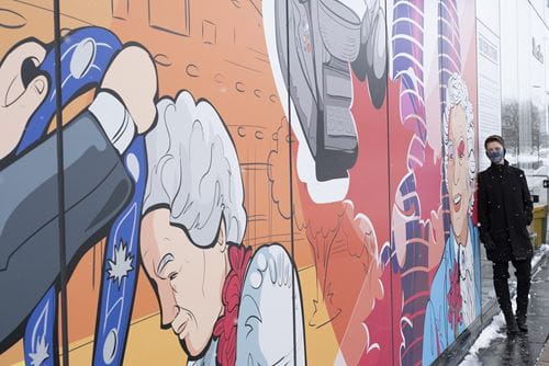 Jude Phillips in front of the mural he designed for Hazel McCallion