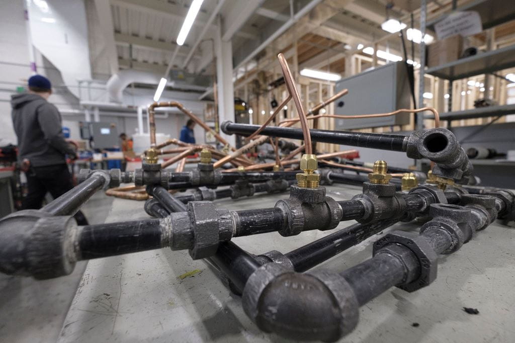 A network of pipes sits on a table in Sheridan's plumbing lab
