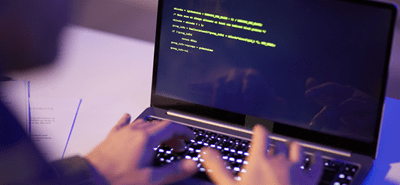 A person types code into a computer
