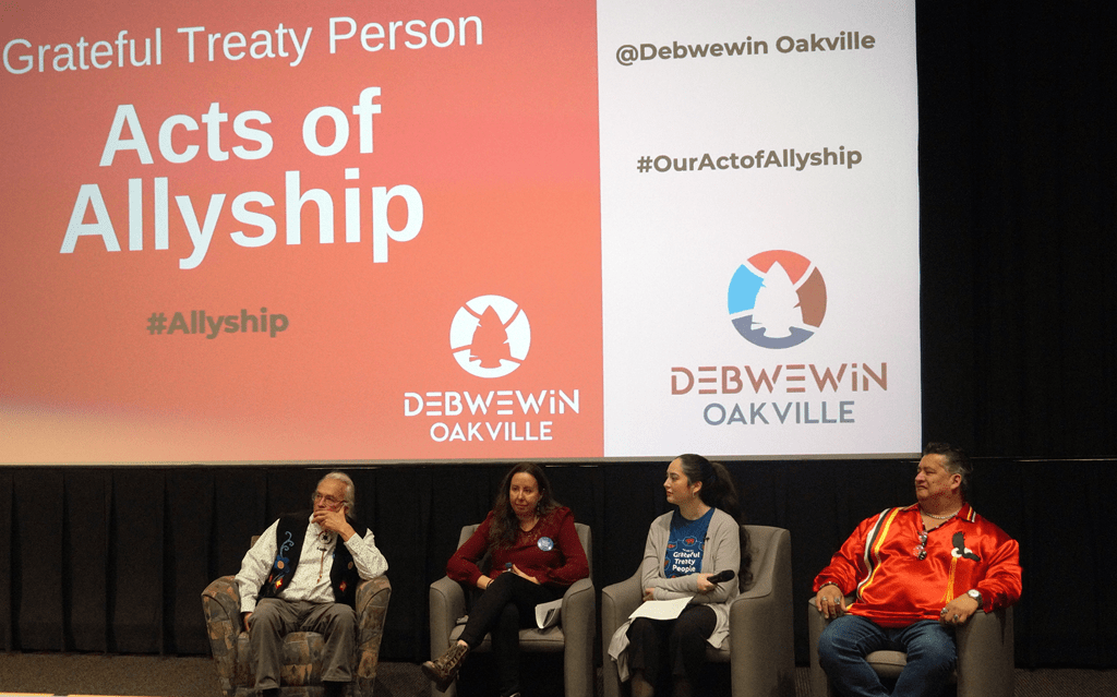 Elder Peter Schuler, Dr. Karine Duhamel, Georgia Laforme and Gimaa (Chief) R. Stacey Laforme sit in chairs on a stage during the Debwewin Workshop.